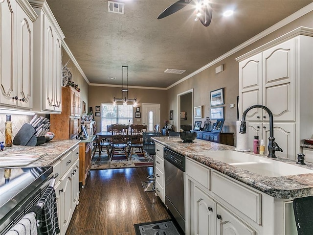 913 E Harrison Ave, Guthrie, OK 73044 - kitchen with a sink, appliances with stainless steel finishes, dark wood-style flooring, white cabinetry, and crown molding