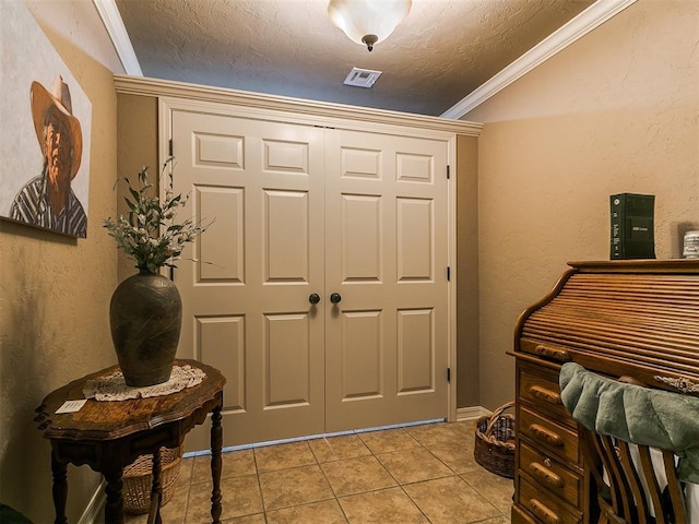 913 E Harrison Ave, Guthrie, OK 73044 - foyer featuring a textured ceiling, light tile patterned floors, crown molding, and lofted ceiling