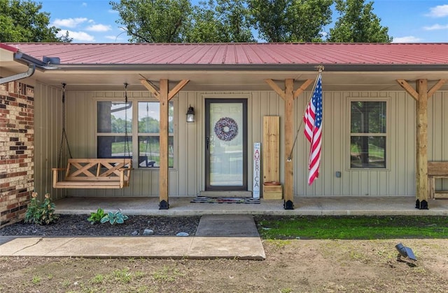 109 W 6th St, Amber, OK 73004 - property entrance featuring covered porch, board and batten siding, and metal roof