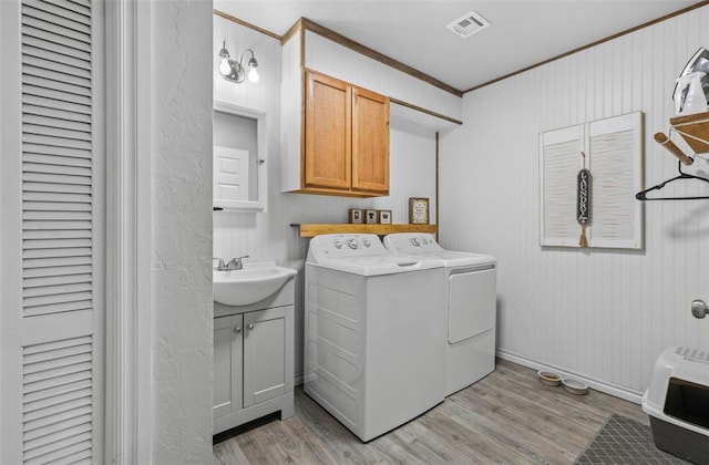 109 W 6th St, Amber, OK 73004 - laundry room with washer and clothes dryer, light wood-type flooring, cabinet space, and heating unit