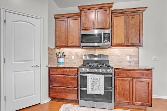 13640 Ridge View Ln, Edmond, OK 73025 - kitchen with stainless steel appliances, decorative backsplash, light stone counters, and baseboards