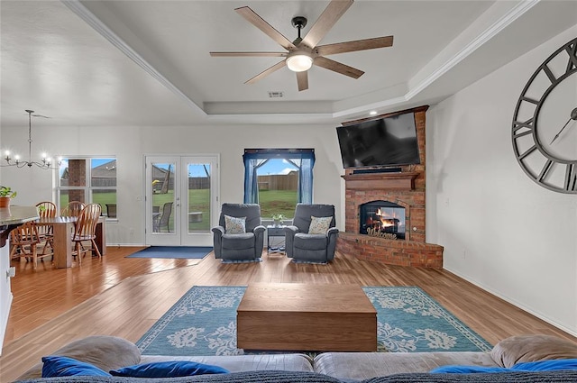 13640 Ridge View Ln, Edmond, OK 73025 - living room with a raised ceiling, ceiling fan, wood finished floors, and a chandelier