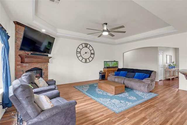 13640 Ridge View Ln, Edmond, OK 73025 - living room featuring a raised ceiling, ceiling fan, arched walkways, and wood finished floors