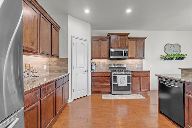 13640 Ridge View Ln, Edmond, OK 73025 - kitchen featuring stainless steel appliances, decorative backsplash, light wood-type flooring, light stone countertops, and recessed lighting