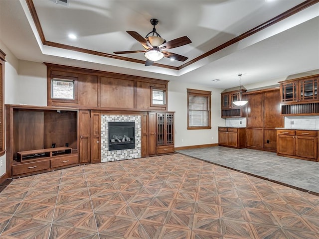 2120 Turtle Creek Dr, Norman, OK 73071 - unfurnished living room with baseboards, a raised ceiling, a ceiling fan, a tile fireplace, and crown molding