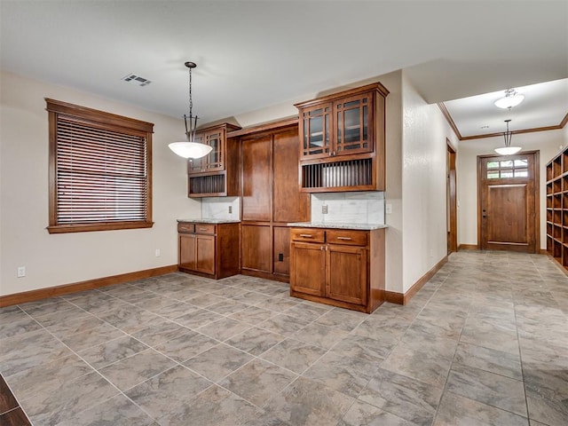 2120 Turtle Creek Dr, Norman, OK 73071 - kitchen with baseboards, brown cabinetry, light stone counters, glass insert cabinets, and crown molding
