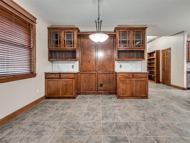 2120 Turtle Creek Dr, Norman, OK 73071 - kitchen featuring light stone counters, baseboards, hanging light fixtures, and glass insert cabinets
