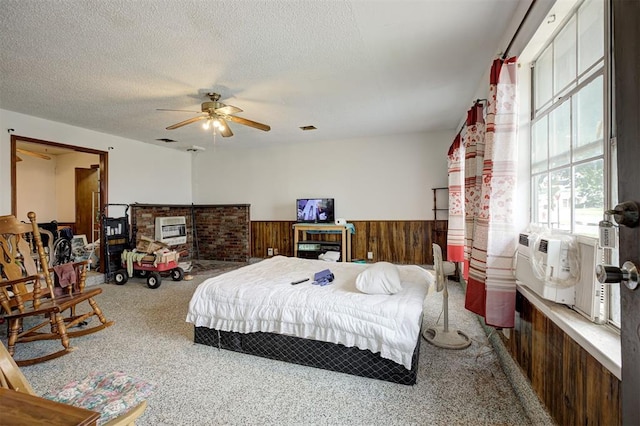 407 S Norman Ave, Moore, OK 73160 - bedroom featuring wainscoting, carpet, wood walls, a textured ceiling, and ceiling fan
