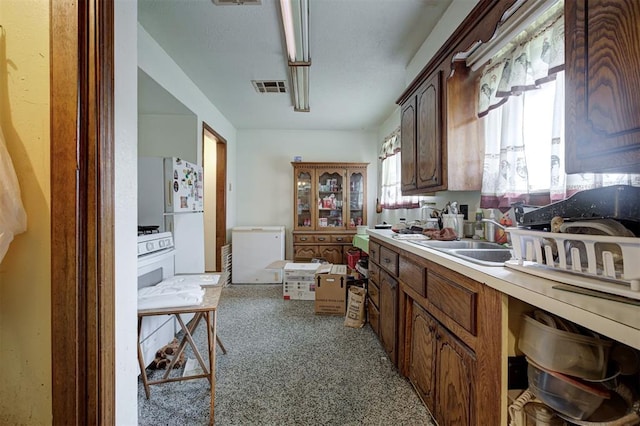 407 S Norman Ave, Moore, OK 73160 - kitchen with freestanding refrigerator, light carpet, and light countertops