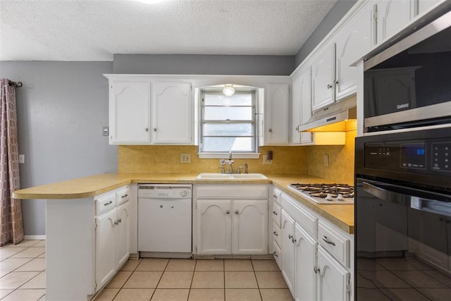 616 Willow Ridge Pl, Edmond, OK 73003 - kitchen with white appliances, a sink, a peninsula, under cabinet range hood, and a textured ceiling