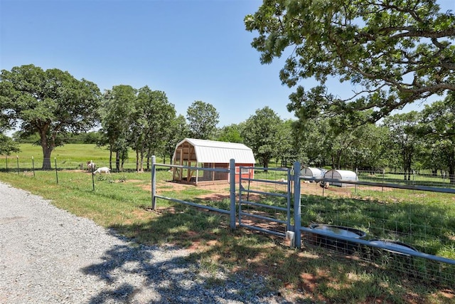 view of yard with an outbuilding, a rural view, and an exterior structure
