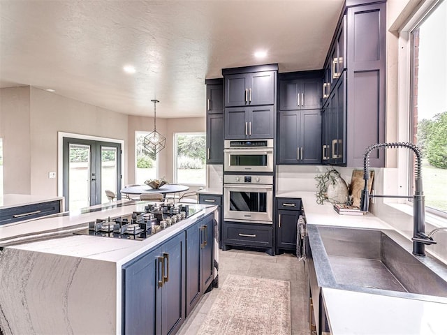 2113 Highlands Lndg, Edmond, OK 73013 - kitchen featuring gas cooktop, a center island, recessed lighting, decorative light fixtures, and light stone counters