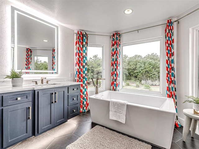 2113 Highlands Lndg, Edmond, OK 73013 - bathroom with vanity, plenty of natural light, tile patterned flooring, a freestanding bath, and recessed lighting