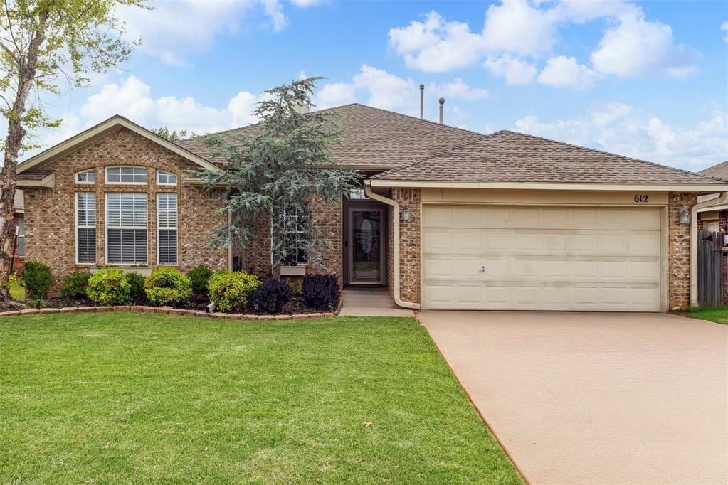 612 Eastview Dr, Yukon, OK 73099 - single story home featuring brick siding, driveway, a front lawn, a garage, and a shingled roof