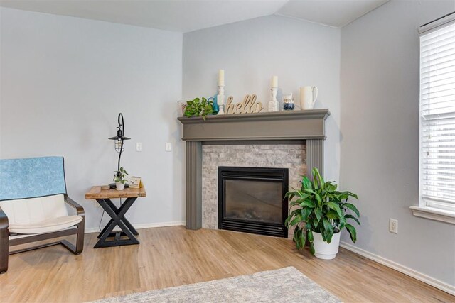 405 Bright Angel Trl, Edmond, OK 73003 - living area featuring wood finished floors, baseboards, a stone fireplace, and vaulted ceiling
