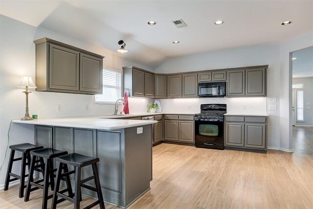 405 Bright Angel Trl, Edmond, OK 73003 - kitchen with black appliances, a peninsula, plenty of natural light, light wood-style flooring, and recessed lighting
