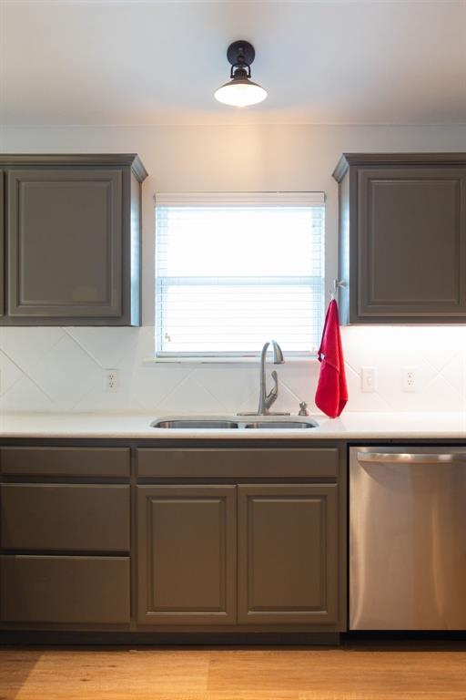 405 Bright Angel Trl, Edmond, OK 73003 - kitchen featuring dishwasher, a sink, backsplash, light countertops, and light wood finished floors