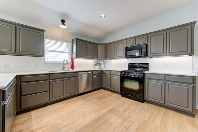 405 Bright Angel Trl, Edmond, OK 73003 - kitchen with black appliances, a sink, light wood-type flooring, backsplash, and lofted ceiling