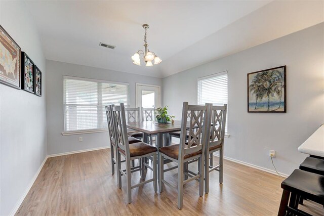 405 Bright Angel Trl, Edmond, OK 73003 - dining area with a chandelier, light wood-style floors, baseboards, and vaulted ceiling