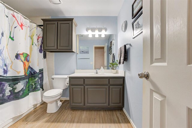 405 Bright Angel Trl, Edmond, OK 73003 - bathroom featuring vanity, toilet, wood finished floors, and a shower with shower curtain