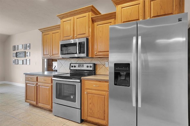 1204 Sheryl Ln, Altus, OK 73521 - kitchen featuring appliances with stainless steel finishes, tasteful backsplash, baseboards, and light tile patterned flooring