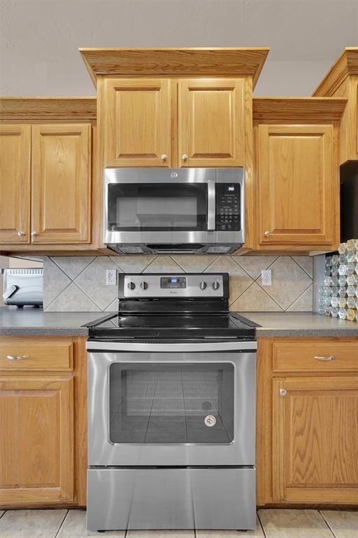1204 Sheryl Ln, Altus, OK 73521 - kitchen with stainless steel appliances, backsplash, and light tile patterned flooring