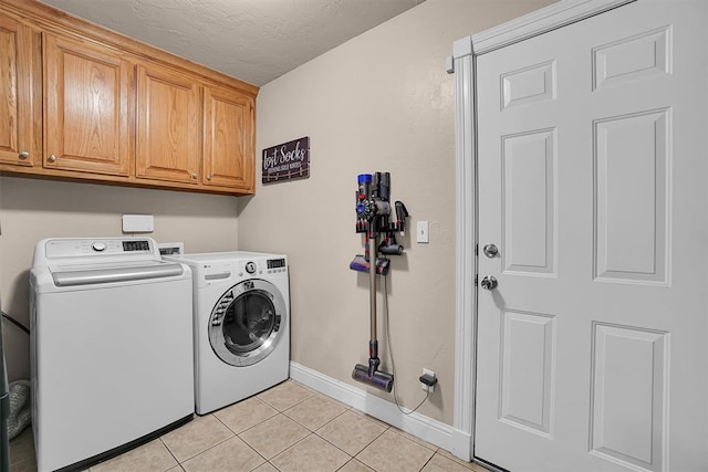 1204 Sheryl Ln, Altus, OK 73521 - laundry room with washer and dryer, cabinet space, light tile patterned flooring, baseboards, and a textured ceiling