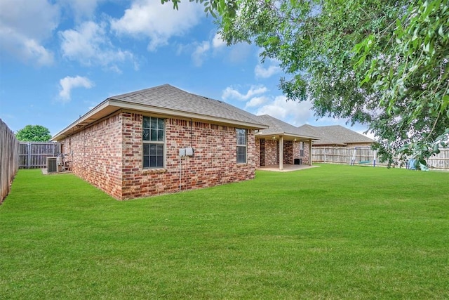 1204 Sheryl Ln, Altus, OK 73521 - back of property featuring central AC unit, brick siding, a patio, and roof with shingles