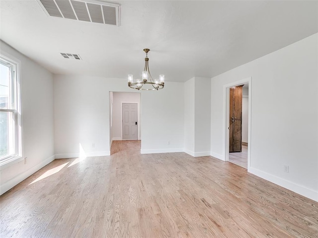 801 N Ash St, Guthrie, OK 73044 - empty room with a chandelier, light wood finished floors, healthy amount of natural light, and baseboards