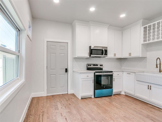 801 N Ash St, Guthrie, OK 73044 - kitchen with appliances with stainless steel finishes, a sink, light countertops, white cabinetry, and recessed lighting