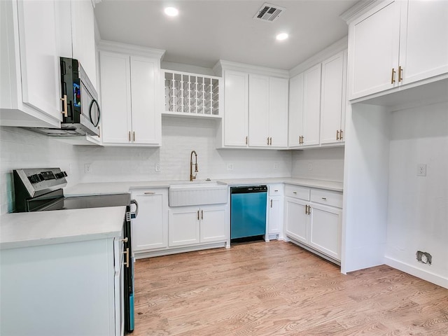801 N Ash St, Guthrie, OK 73044 - kitchen with appliances with stainless steel finishes, a sink, white cabinetry, light countertops, and decorative backsplash
