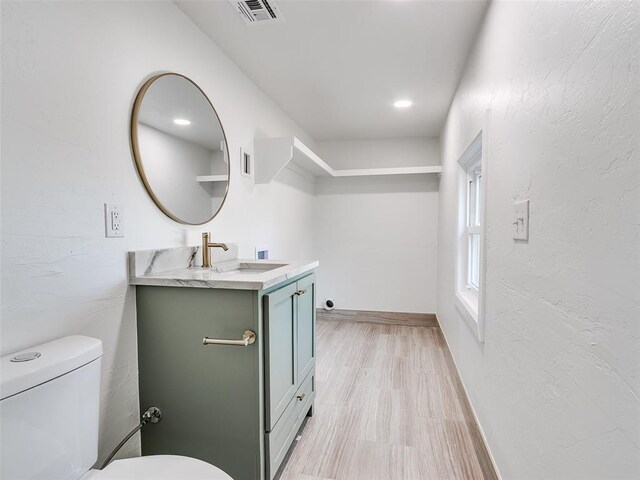 801 N Ash St, Guthrie, OK 73044 - bathroom with vanity, toilet, wood finished floors, and baseboards