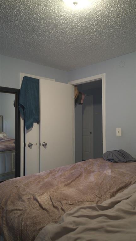 428 NW 91st St, Oklahoma City, OK 73114 - bedroom featuring a closet and a textured ceiling