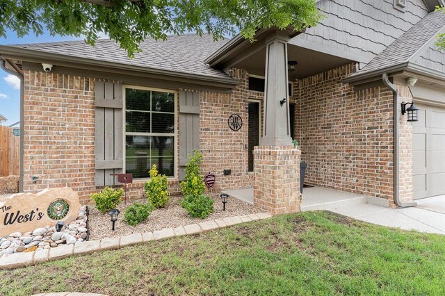 17912 Marron Dr, Edmond, OK 73012 - view of exterior entry with brick siding, roof with shingles, and a surveillance system