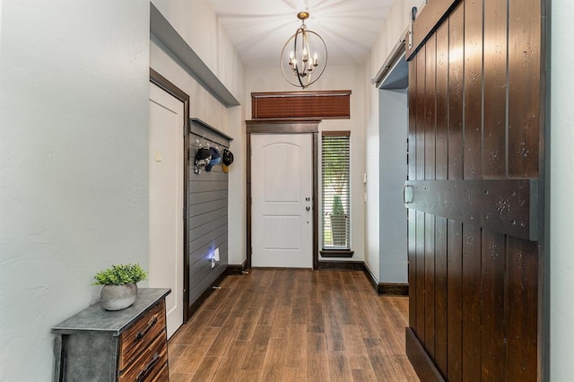 17912 Marron Dr, Edmond, OK 73012 - entrance foyer featuring dark wood-style flooring, a chandelier, baseboards, and a barn door