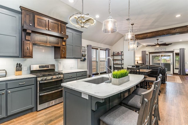 17912 Marron Dr, Edmond, OK 73012 - kitchen with double oven range, a sink, open floor plan, tasteful backsplash, and hanging light fixtures