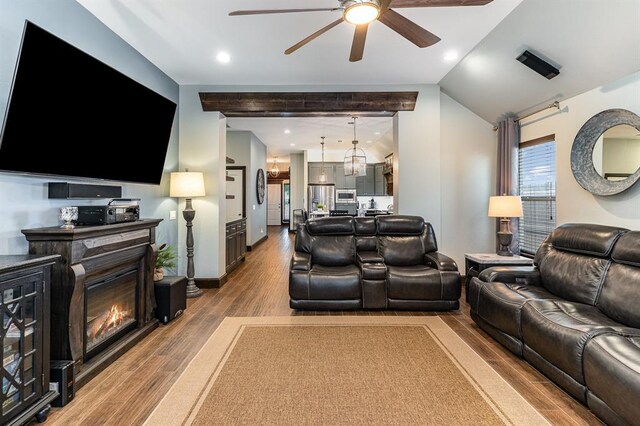 17912 Marron Dr, Edmond, OK 73012 - living room with a ceiling fan, wood finished floors, a glass covered fireplace, lofted ceiling, and recessed lighting