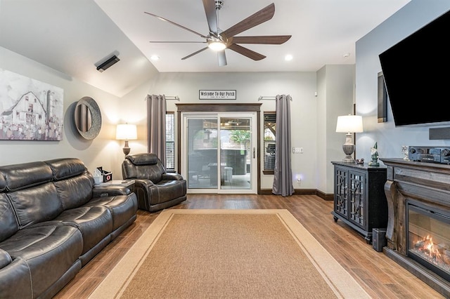 17912 Marron Dr, Edmond, OK 73012 - living area featuring a ceiling fan, wood finished floors, a glass covered fireplace, baseboards, and lofted ceiling