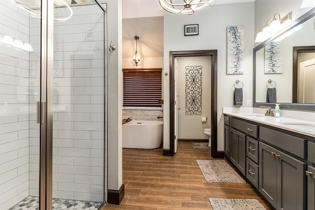 17912 Marron Dr, Edmond, OK 73012 - full bathroom featuring a shower stall, a freestanding tub, double vanity, and wood finished floors