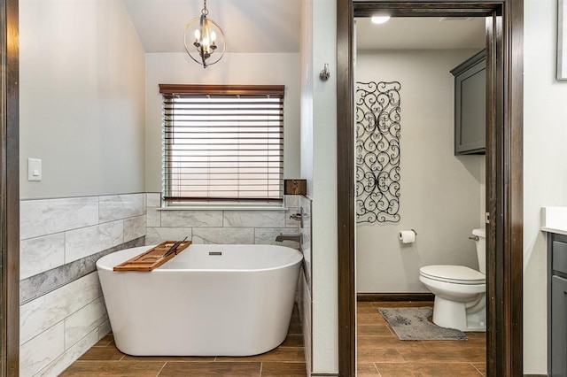 17912 Marron Dr, Edmond, OK 73012 - bathroom featuring a soaking tub, tile walls, vanity, wood finish floors, and toilet
