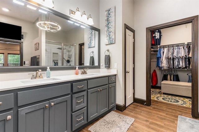 17912 Marron Dr, Edmond, OK 73012 - bathroom with a shower stall, double vanity, wood finished floors, and a spacious closet