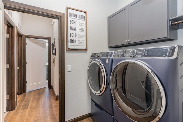 17912 Marron Dr, Edmond, OK 73012 - washroom featuring washing machine and clothes dryer, cabinet space, light wood-style flooring, and baseboards