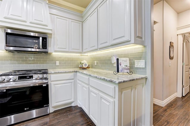 3366 Antler Vly, Guthrie, OK 73044 - kitchen with appliances with stainless steel finishes, ornamental molding, dark wood-type flooring, white cabinetry, and light stone counters
