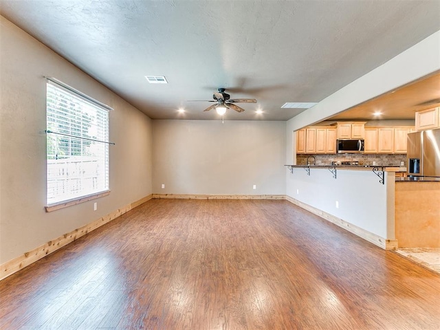 613 S Avery St, Moore, OK 73160 - unfurnished living room with light wood finished floors, a ceiling fan, and baseboards