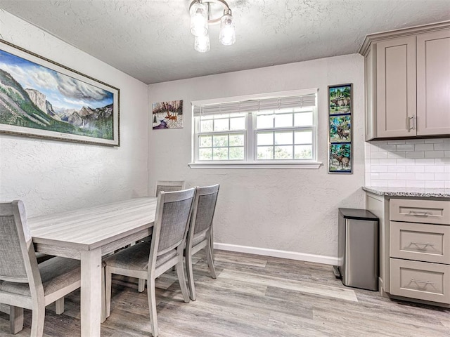 621 W 2nd St, Calumet, OK 73014 - dining room featuring light wood-style floors, a textured ceiling, a textured wall, and baseboards