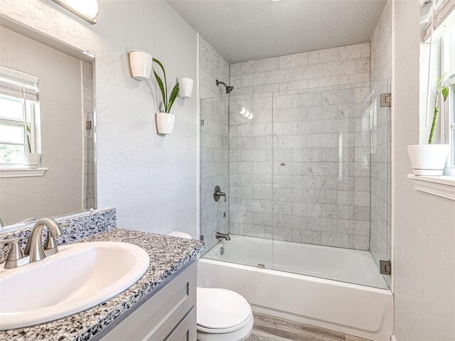 621 W 2nd St, Calumet, OK 73014 - full bathroom featuring vanity, toilet, enclosed tub / shower combo, wood finished floors, and a textured wall