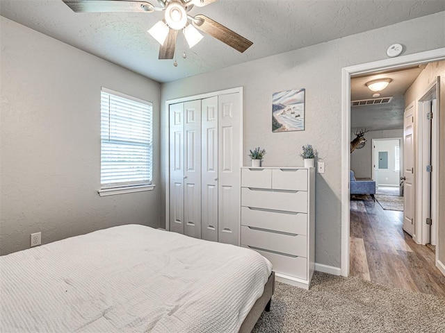 621 W 2nd St, Calumet, OK 73014 - carpeted bedroom featuring a textured wall, baseboards, ceiling fan, a textured ceiling, and a closet
