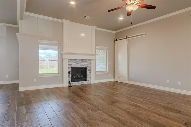 12916 Ponderosa Blvd, Oklahoma City, OK 73142 - unfurnished living room featuring a barn door, ceiling fan, dark wood-style flooring, ornamental molding, and baseboards