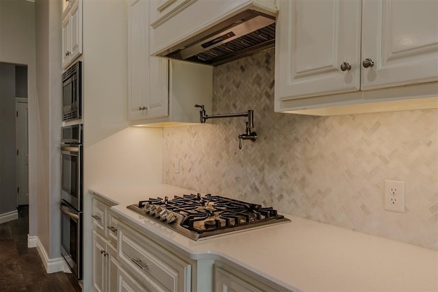 12916 Ponderosa Blvd, Oklahoma City, OK 73142 - kitchen featuring custom range hood, appliances with stainless steel finishes, light countertops, backsplash, and white cabinetry