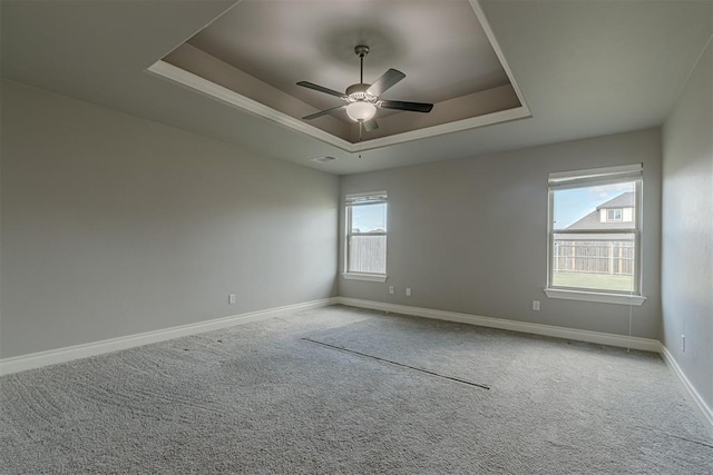 12916 Ponderosa Blvd, Oklahoma City, OK 73142 - spare room with a tray ceiling, carpet, baseboards, and a ceiling fan